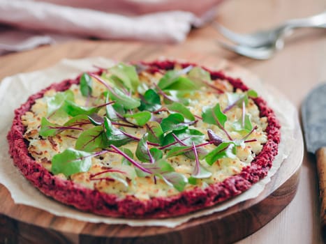 beetroot pizza crust with fresh swiss chard or mangold, beetroot leaves. Ideas and recipes for vegan snack.Egg-free pizza crust with chia seeds and wholegrain brown rice flour. Copy space. Shallow DOF