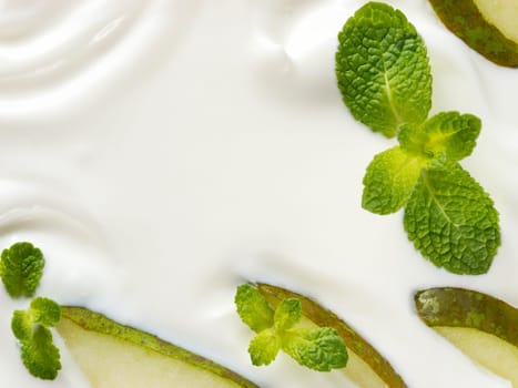 greek yogurt or sour cream texture with pear slice and mint leaf. Close up with copy space. Top view or flat lay