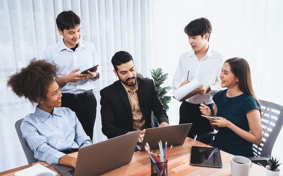 Happy diverse business people work together, discussing in corporate office. Professional and diversity teamwork discuss business plan on desk with laptop. Modern multicultural office worker. Concord