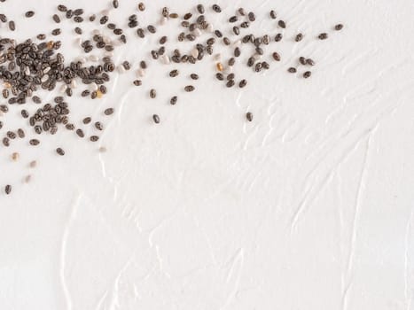 Chia seeds with copy space. Chia seed on white concrete textured background. Top view or flat lay. Copy space. Healthy food and diet concept