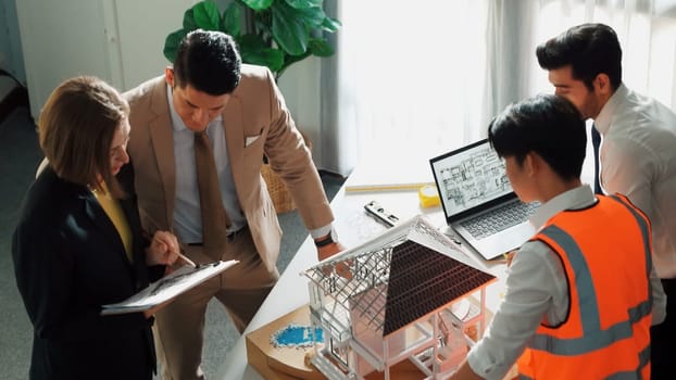 Top view of professional architect engineer team inspect house model while manager holding blueprint and asking about building construction. Group of diverse engineer working together. Alimentation.