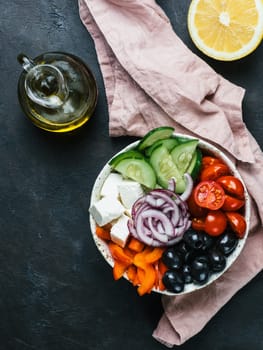 Greek Salad Bowl on dark black background. Above view of Bowl Greek Salad. Trendy food. Idea, recept and concept of modern healthy food. Vertical. Copy space for text.