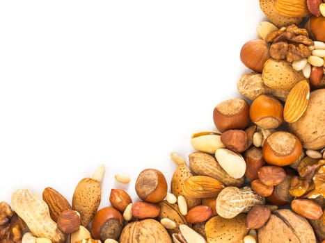 Background of mixed nuts - hazelnuts, almonds, walnuts, pistachios, peanuts, pine nuts peeled and not peeled - vertical with copy space. Isolated one edge. Top view or flat lay