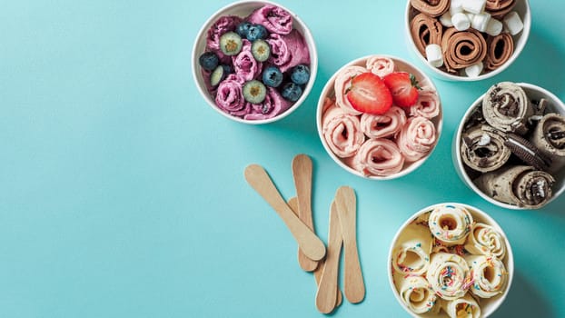 rolled ice creams in cone cups on blue background. Different iced rolls top view or flat lay. Thai style rolled ice cream with copy space for text or design. Banner