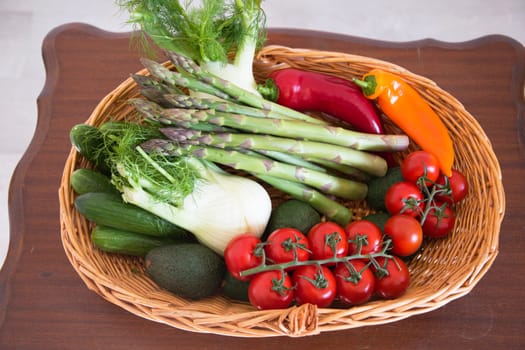 fresh assorted Vegetables in a basket on a wooden table, consumer vegetarian basket, tomatoes, fennel, paprika, asparagus,, cucumbers, avocado, Healthy eating concept, top view, High quality photo