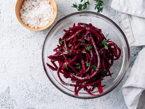 Raw beetroot noodles salad. Vegetable noodles - beet spaghetti on gray cement background. Copy space for text. Ideas and recipe for Clean eating, raw vegetarian food concept. Top view or flat lay.