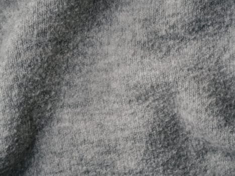 Gray sweater fabric texture. Clothes sweater background with folds