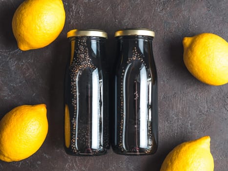 Detox activated charcoal black chia water or lemonade with lemon. Two bottle with black chia infused water. Detox drink idea and recipe. Vegan food and drink. Top view
