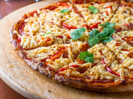 Pizza on wooden plate at restaurant table. Close up