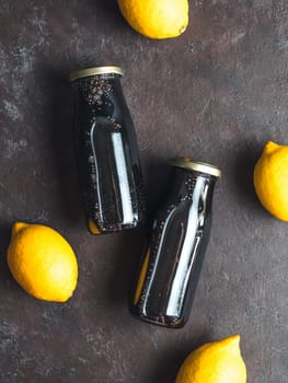 Detox activated charcoal black chia water or lemonade with lemon. Two bottle with black chia infused water. Detox drink idea and recipe. Vegan food and drink. Top view. Copy space for text.