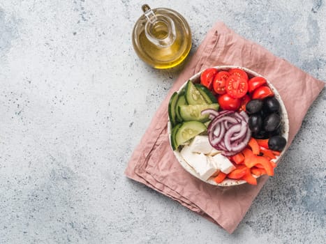 Greek Salad Bowl on gray cement background, copy space. Above view of Bowl Greek Salad. Trendy food. Idea, recept and concept of modern healthy food.