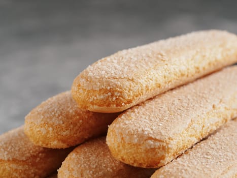 Close up view of ladyfinger biscuit cookie on gray concrete background. Italian cookie savoiardi. Copy space.