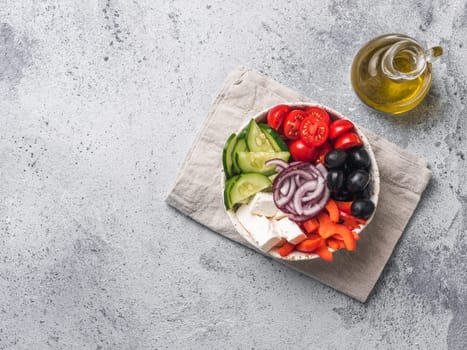 Greek Salad Bowl on gray cement background, copy space. Above view of Bowl Greek Salad. Trendy food. Idea, recept and concept of modern healthy food.