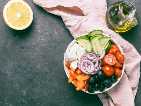 Greek Salad Bowl on dark black background, copy space. Above view of Bowl Greek Salad. Trendy food. Idea, recept and concept of modern healthy food.