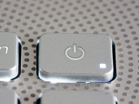 Silver laptop power button close up. Shallow DOF