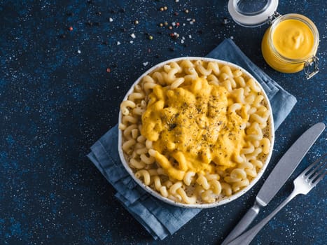 Pasta with vegan creamy chia cheddar sauce on gray background. Ideas and recipe for healthy diet or vegan food. Dish with homemade plant based Chia Cheeze Sauce. Copy space