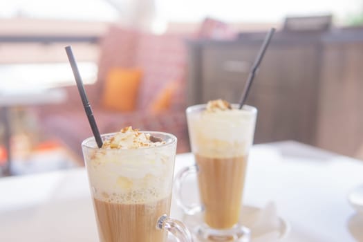 coffee is served in a tall glass glass with a straw. The concept of coffee drinks from the bar menu.