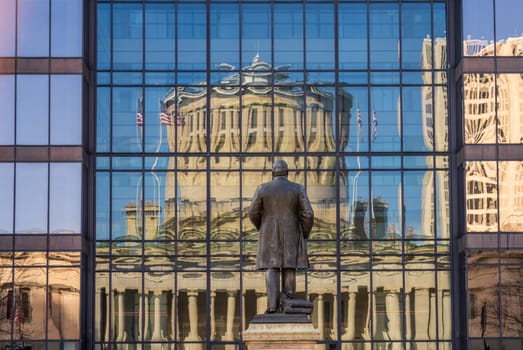 McKinley memorial in front of a reflection of the Ohio state Capitol building in the windows of an office building across the street in Columbus, OH