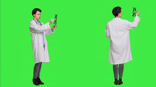 General practitioner examining radiography scan against greenscreen backdrop, looking at x ray results to find diagnosis. Physician in white coat uses radiology science and research. Camera A.