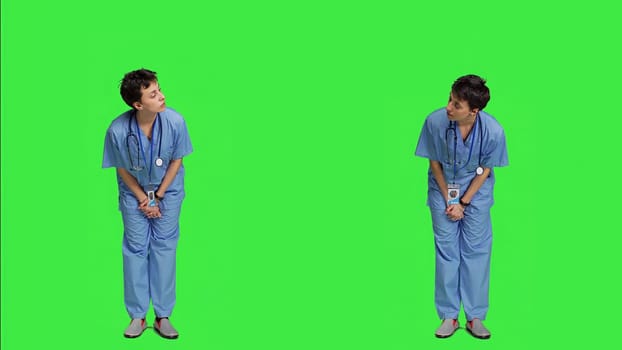 Medical assistant being impatient against greenscreen backdrop, looking around and waiting for patients at consultations. Nurse with health expertise feeling frustrated while she waits. Camera A.