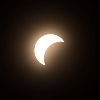 Early stage of the solar eclipse in April 2024 with the moon starting to cover the sun