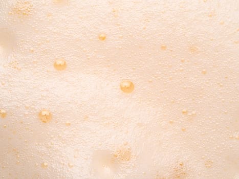 Foam texture extreme close up as background. Milkshake or cappucino foam with bubbles macro shoot. Copy space for text.