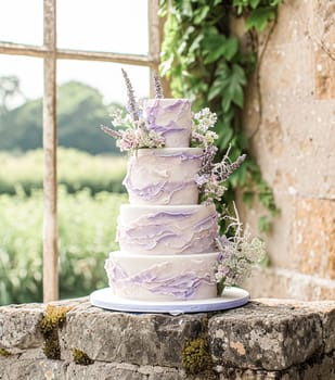 Wedding table decoration with lavender flowers, sweets, cake and candles