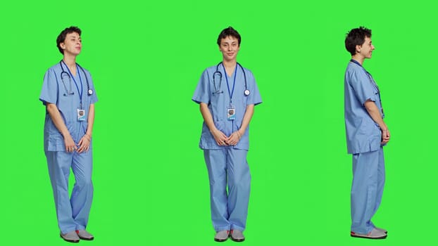 Portrait of medical assistant smiling and posing with confidence, standing against greenscreen backdrop. Nurse wears blue scrubs and stethoscope, feeling successful with health expertise. Camera A.