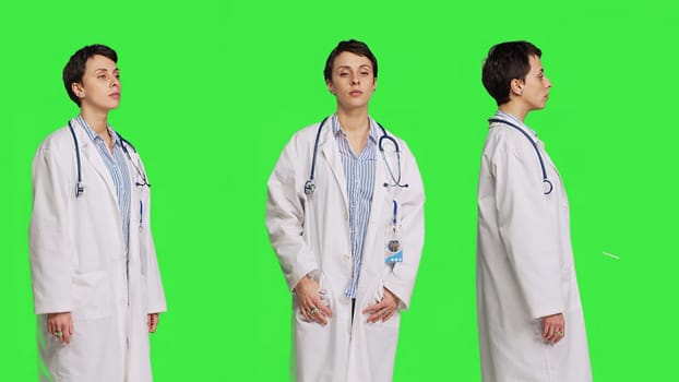 Portrait of health specialist wearing a white hospital coat in studio, standing against greenscreen backdrop. Successful doctor posing with confidence, medical industry expertise. Camera B.