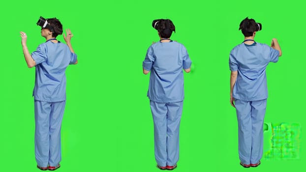 Medical assistant uses interactive vr glasses to check disease treatment, looking at patient examination files with virtual reality headset and lens. Nurse against greenscreen backdrop. Camera A.
