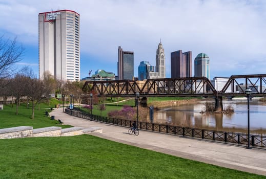 Columbus, OH - 7 April 2024: Waterfront view of the downtown financial district from the River Scioto through a railroad truss bridge