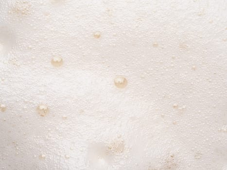 Foam texture extreme close up as background. Beer or cappucino foam with bubbles macro shoot. Copy space for text.