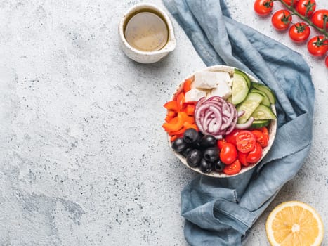 Greek Salad Bowl on gray cement background, copy space. Above view of Bowl Greek Salad. Trendy food. Idea, recept and concept of modern healthy food.