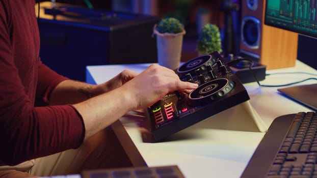 Music producer mixing individual tracks into a stereo in home studio, artist adjusting levels, panning and special effects to achieve a balanced audio. Musician does acoustical engineering. Camera A.