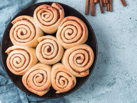 Idea and recipe pastries - perfect cinnamon rolls, top view in skillet. Vegan swedish cinnamon buns Kanelbullar with pumpkin spice. Flat lay. Copy space for text