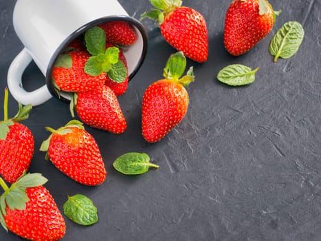 Fresh red strawberries on dark background. Strawberry in rustic cup on oriental black background. Top view or flat lay. Copyspace