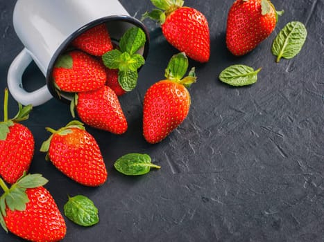 Fresh red strawberries on dark background. Strawberry in rustic cup on oriental black background. Top view or flat lay. Copyspace