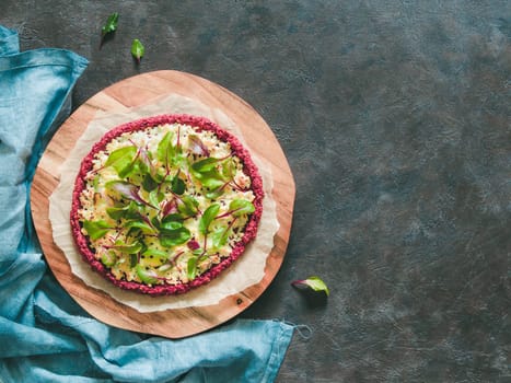beetroot pizza crust with fresh swiss chard or mangold beetroot leaves.Ideas and recipes for healthy vegan snack.Egg-free pizza crust with chia seed and wholegrain brown rice flour.Copy space.Top view