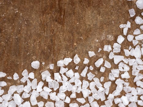 coarse salt closeup on baking parchment background with copy space. Top view or flat lay.