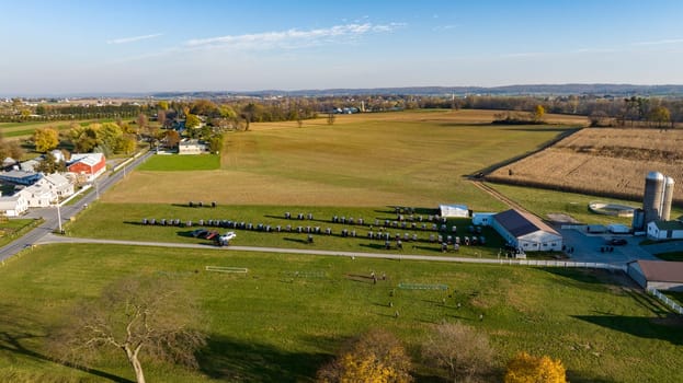 This aerial image displays the vast beauty of Amish farmland at dusk, with a serene sunset backdrop, highlighting the community's harmonious blend with nature for an Amish wedding.