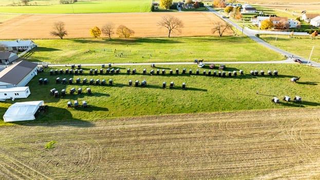 A vivid aerial photograph captures Amish buggies neatly arranged at a community event, surrounded by the vibrant colors of fall harvest fields., during an Amish wedding