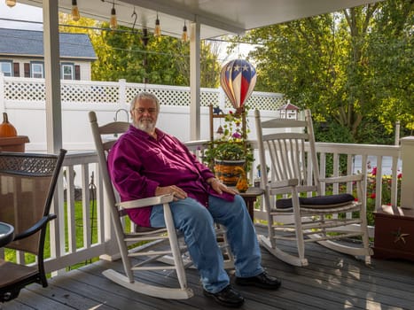 A Senior Aged Male Resting in a Rocking Chair, on a Deck, Enjoying His Retirement on a Autumn Day