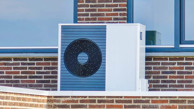 air source heat pump unit installed outdoors at a modern home in the Netherlands in spring, warmte pomp translation air source heat pump, energy transition from natural gas to electric source