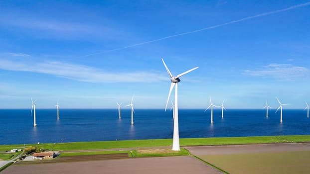 offshore windmill park and a blue sky, windmill park in the ocean. Netherlands Europe. windmill turbines in the Noordoostpolder Flevoland, clean green energy, carbon neutral, Earth day