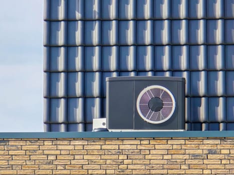 air source heat pump unit installed outdoors at a modern home with bricks in the Netherlands in spring, warmte pomp translation air source heat pump, carbon neutral zero emissions