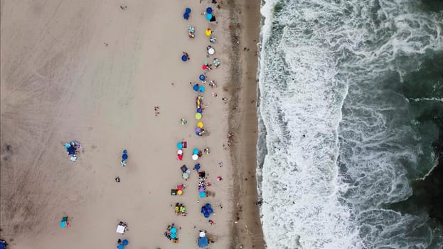 Beautiful aerial view with drone to one of the beaches south of Lima in Peru where you can see umbrellas and people enjoying the summer. 2.7k resolution