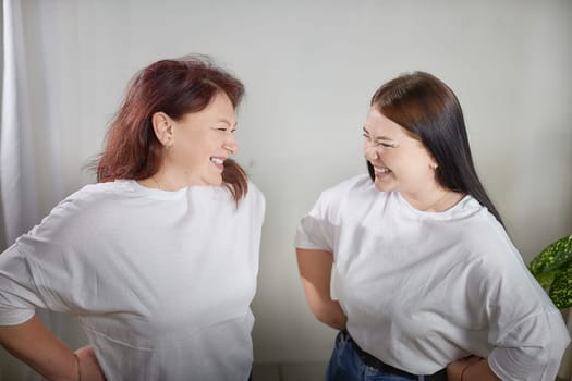 Happy Overweight family with mother and daughter in room. Middle aged woman and teenager girl having fun, joy and hugging