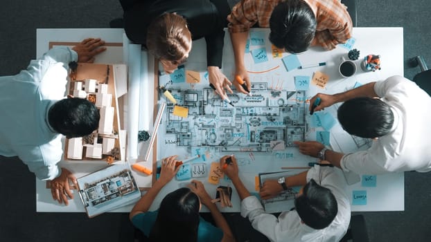 Top aerial view of project manager or civil engineer writing at blueprint and planning building design. Aerial view of architect working together at meeting table with document placed. Alimentation.