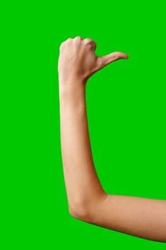 A close-up view captures the extended arm of an individual showing a thumbs up sign, denoting approval or success. The arm is poised against a vibrant green screen backdrop which is commonly used for chroma key compositing in video production and photography.