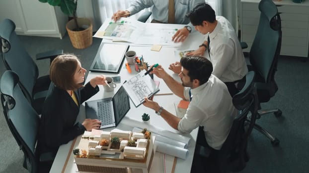 Group of diverse team planning strategy while sitting at table with project plan. Top aerial view of smart business people working together to brainstorm and design house construction. Alimentation.